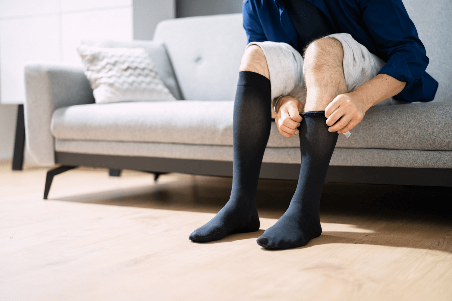 A man putting on black compression socks